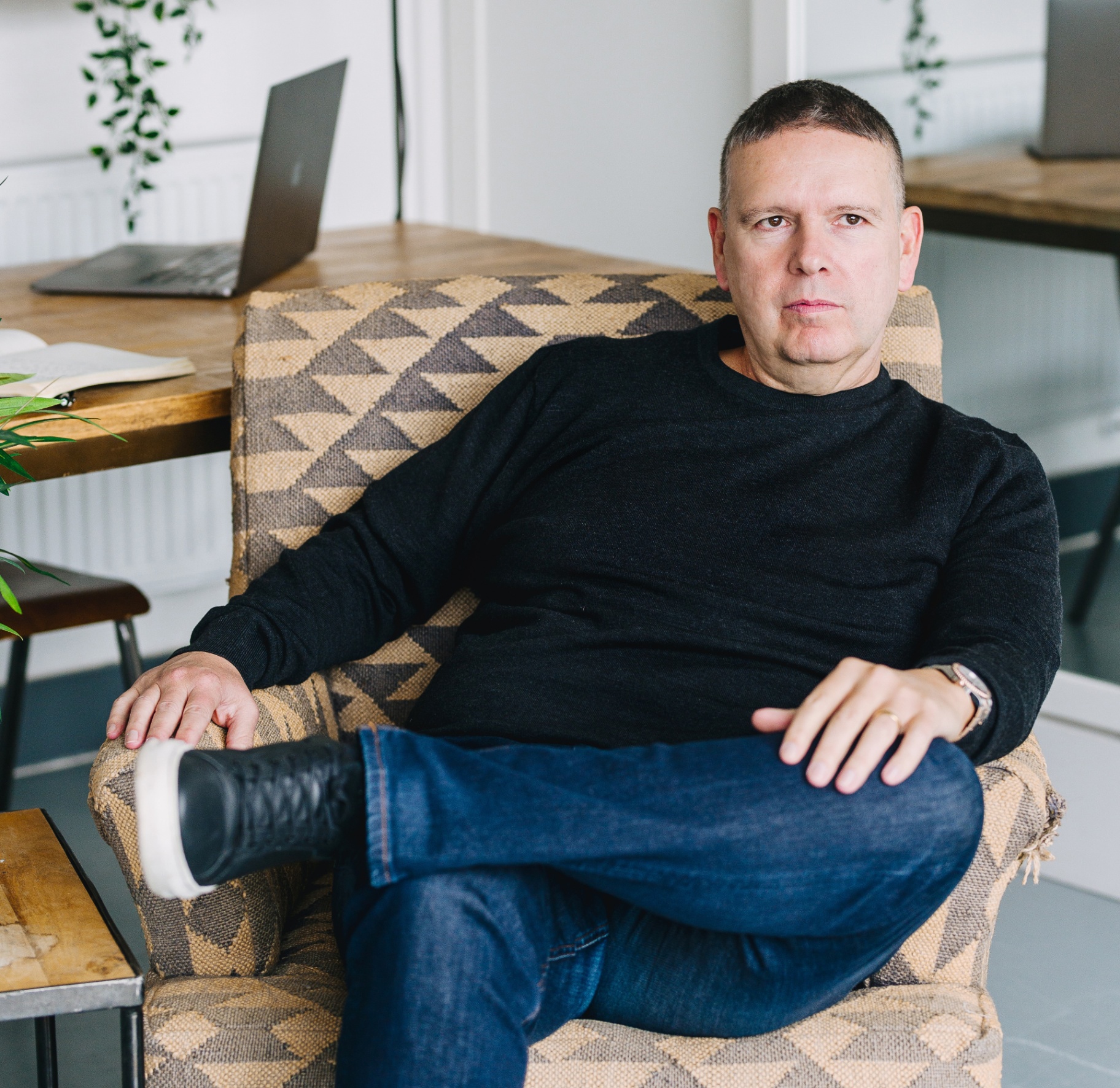 Steve Matthews seated in an armchair in his studio
